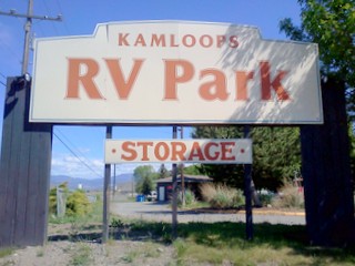 picture of park staff in front of Kamloops RV Park sign